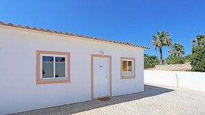 A single-story building with a tiled roof, a white exterior, and two windows with brown frames. - X 10 - 2 Bed Apartment in Quinta da Ponte (Lagos)