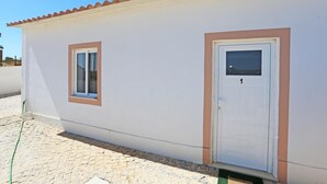A small, single-story building with a tiled roof, a white exterior, and a single door with a window. - X 01 - 2 Bed Apartment in Quinta da Ponte (Lagos)