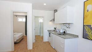A compact kitchen with white cabinets, a granite countertop, and a built-in dishwasher. - X 04 - 1 Bed Apartment in Quinta da Ponte (Lagos)
