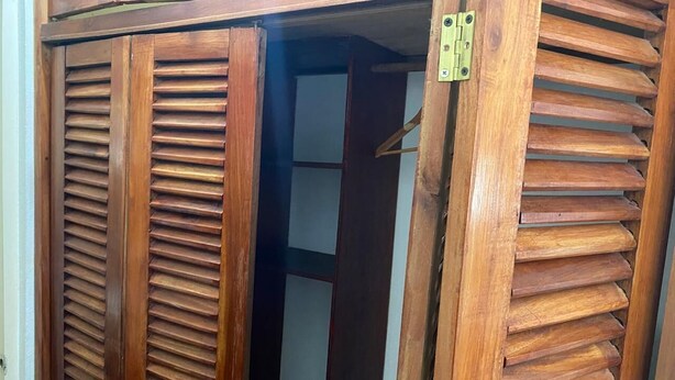 A wooden wardrobe with horizontal slats and a visible door handle.