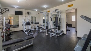 A gym with various exercise equipment, mirrors, and a sign indicating a private area. - Studio With Balcony Sp-an606 (São Paulo)