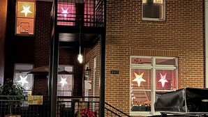 A two-story brick building with a balcony, a car parked in front, and a blue trash bin. - Cozy 2-bedroom Townhome with free parking in charming Downtown Chattanooga (Chattanooga)