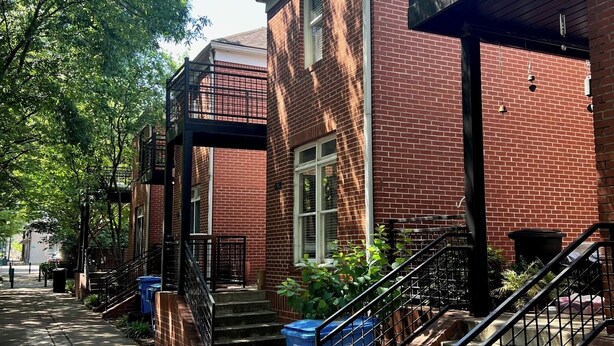 A row of brick buildings with a covered walkway and stairs leading to the entrance. - Cozy 2-bedroom Townhome with free parking in charming Downtown Chattanooga (Chattanooga)