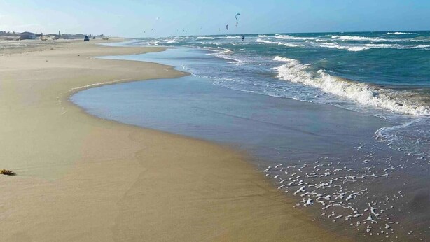 A beach with clear skies, waves, and a few kites. - Charming bungalow in garden with lot of privacy - in an exclusive condo. (Guajiru Trairi)