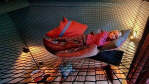 A room with a hammock bed, a small table, and a chair. - Charming 3-bedroom house in enchanting Ternaard with WiFi, AC "Us Eigen Honk" (Ternaard)
