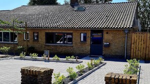 A brick building with a tiled roof, a door, and windows. There are small plants in front of the building. - Charming 3-bedroom house in enchanting Ternaard with WiFi, AC "Us Eigen Honk" (Ternaard)