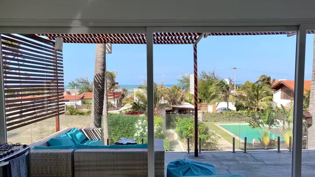 En balkong med utsikt över havet, en pool och en matplats.