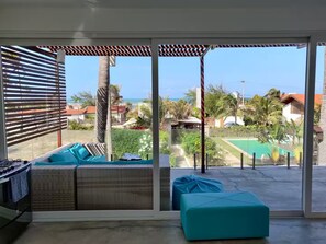 En balkon med havudsigt, en pool og et spiseområde.