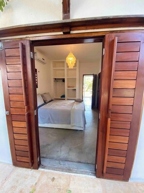 Une chambre à coucher avec un lit, une armoire et un luminaire suspendu.