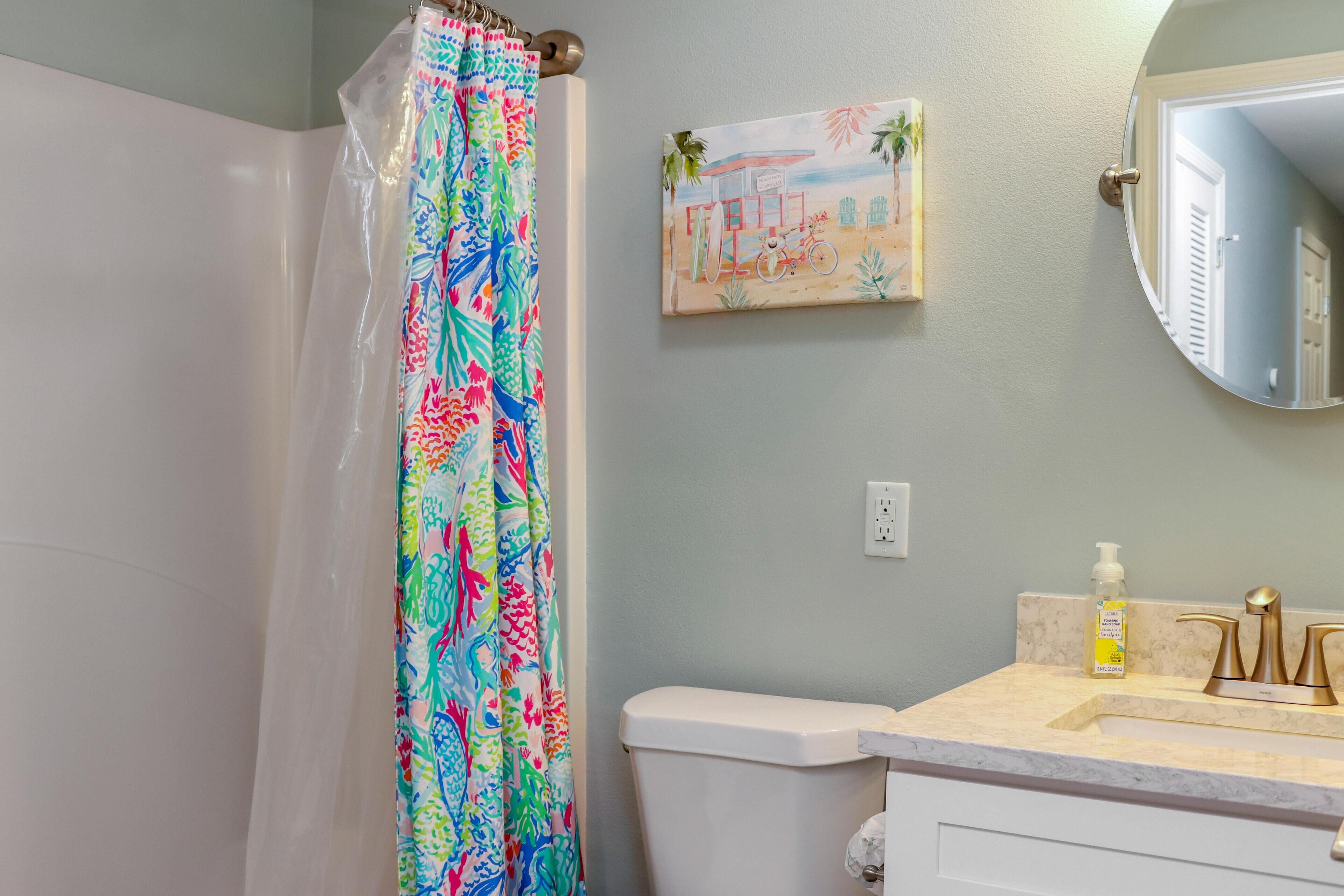 A bathroom with a toilet, sink, and shower curtain.