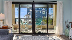 A room with a sliding glass door leading to a balcony with outdoor furniture. - Club at Mexico Beach 1K Forgotten Cove (Port St. Joe)