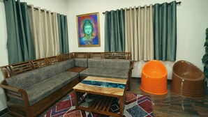Una sala de estar con un sofá de madera, una mesa de centro y un tapete colorido.
