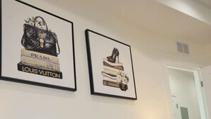 A bed with blue bedding, a framed picture of a handbag, and a framed picture of a shoe on the wall. - Modern Cozy Apartment, Free Parking, Wi-Fi, Near Dining and Downtown. (Chicago)