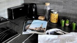 A kitchen counter with a toaster, coffee maker, jars, and a SeasonLoc concierge bag.