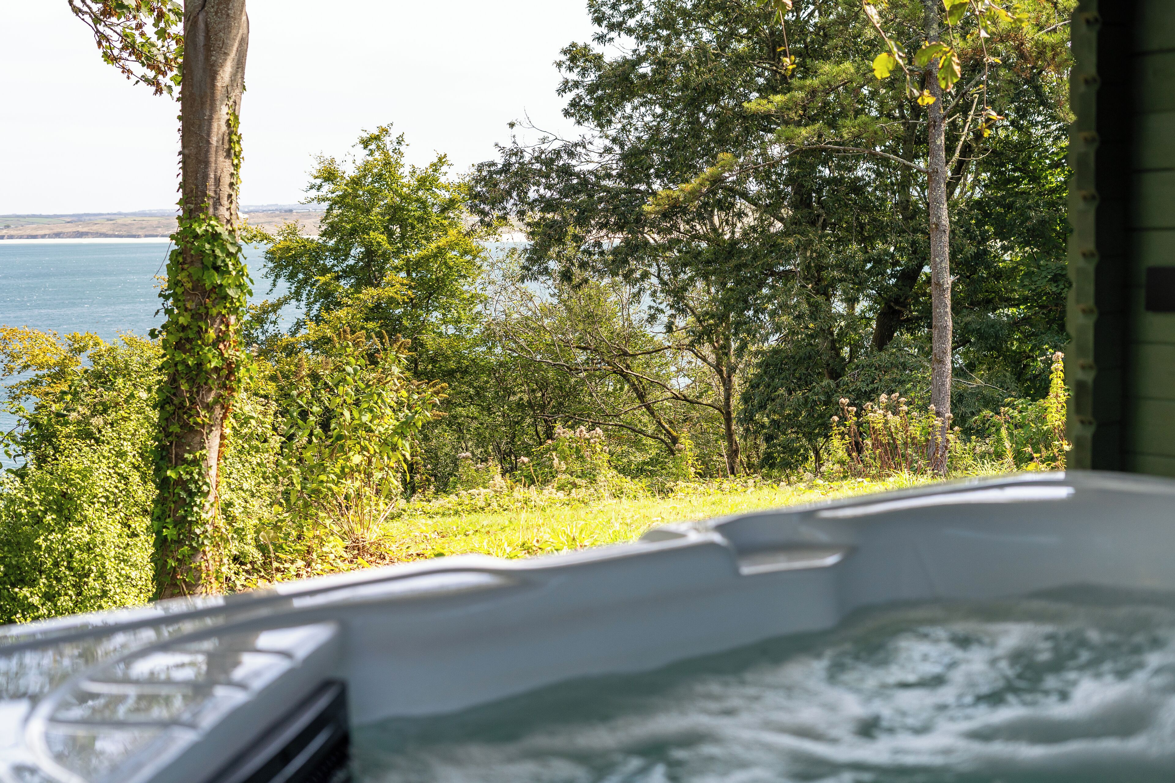 A hot tub with a view of a lake and surrounding trees.