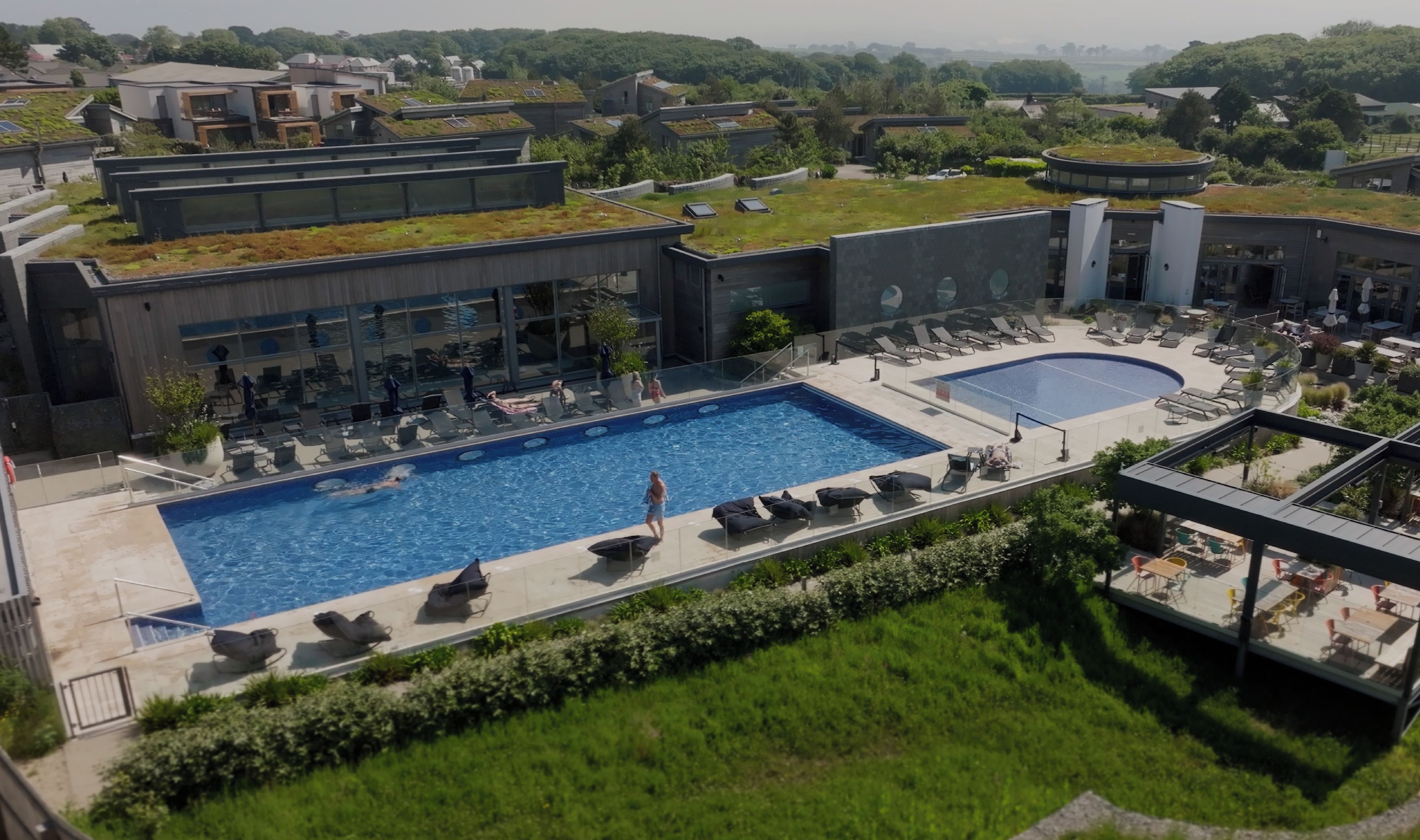 A modern spa, pool, and fitness suite with a rooftop garden and outdoor seating area.
