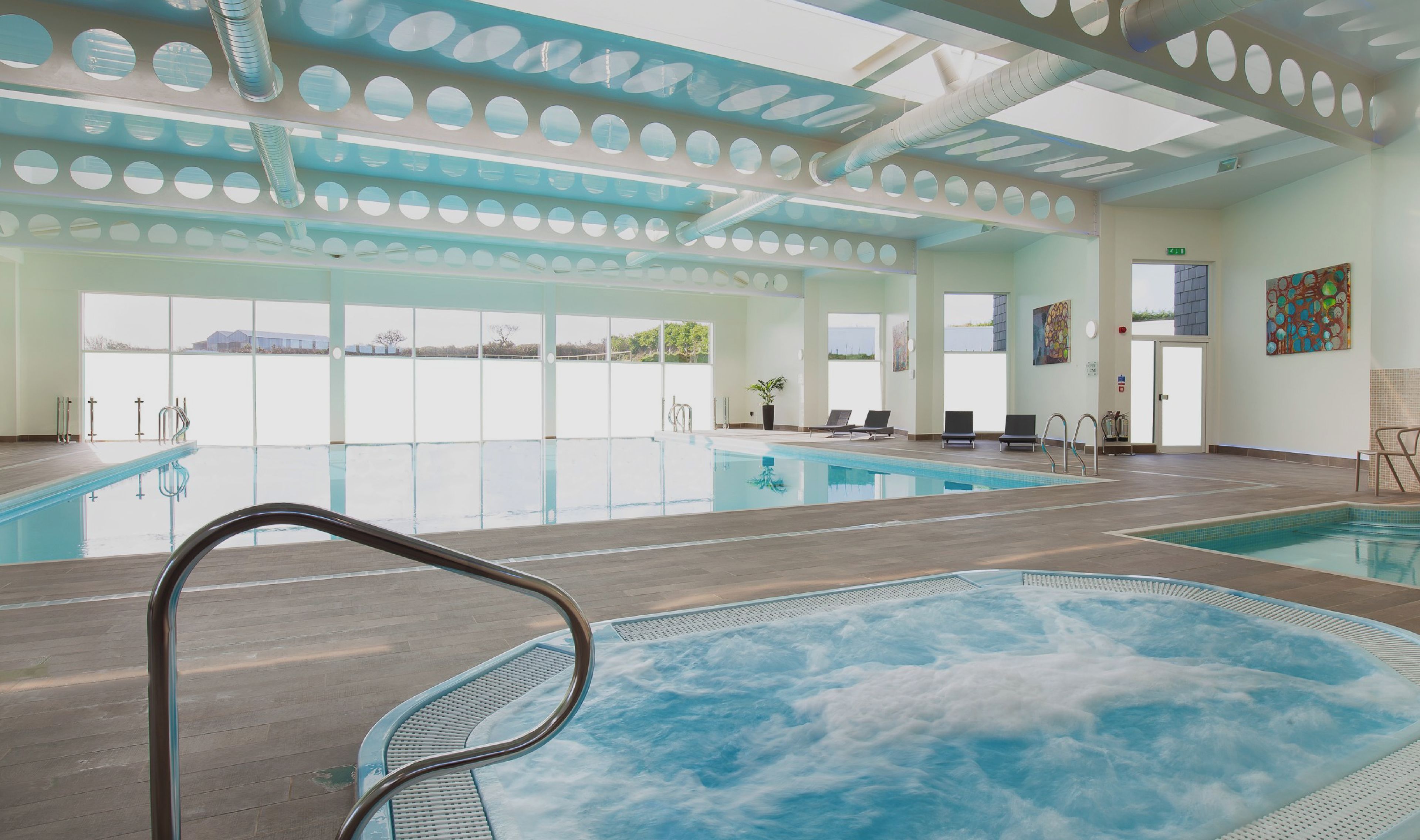 A spa, pool, and fitness suite with a large indoor pool, a hot tub, and exercise equipment.