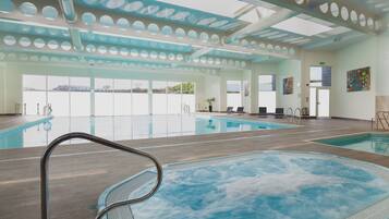 A spa, pool, and fitness suite with a large indoor pool, a hot tub, and exercise equipment.