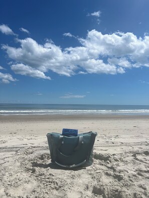 A beach chair with a blue object on it, facing the ocean. - Charming studio in lovely Emerald Isle with beach access (Emerald Isle)