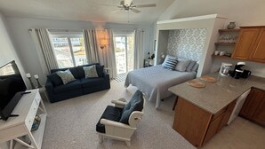 A compact living space with a bed, sofa, and kitchenette. - Charming studio in lovely Emerald Isle with beach access (Emerald Isle)