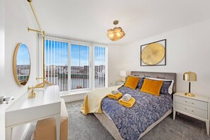 A hotel room with a bed, bedside tables, a mirror, a window with a view, and a ceiling light.