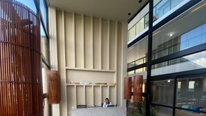 Un hall amplio con mostrador de recepción, zona de estar y ventanas grandes.