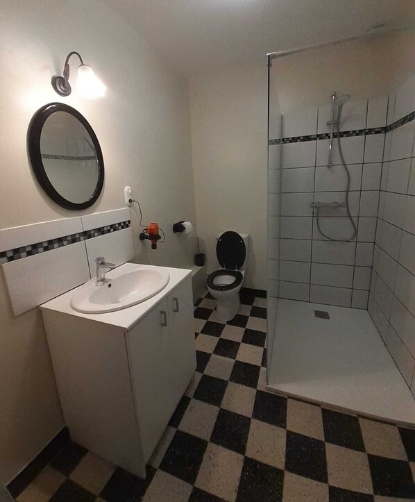 A bathroom with a sink, toilet, and shower.