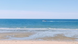 A beach with clear blue water and a boat in the distance. - Sea Esta Villa by Kivoya (Puerto Peñasco)
