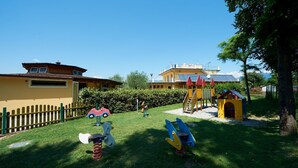 A playground with swings, slides, and a climbing structure. - Vacation resort Baia Verde Mobile Home Suite Deluxe for 5 persons (Manerba del Garda)