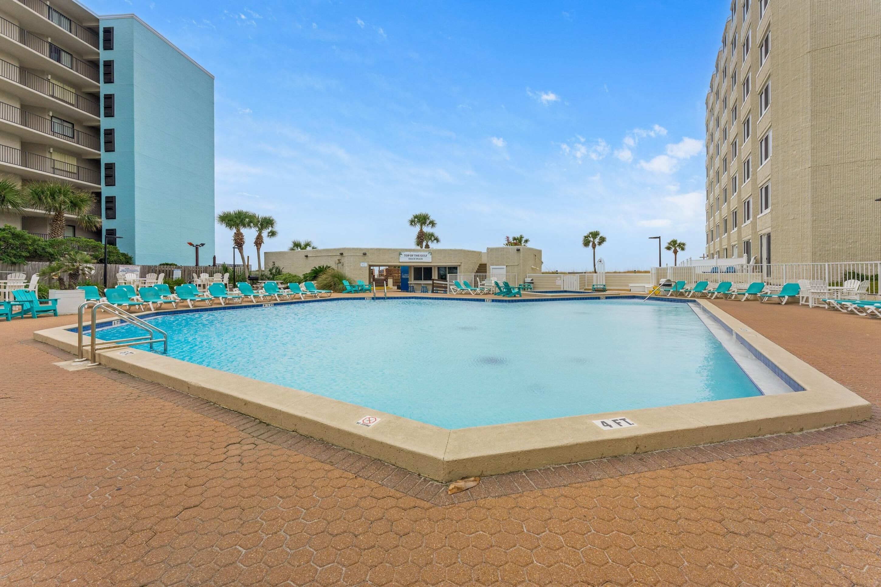 En säsongsöppen utomhuspool och solstolar