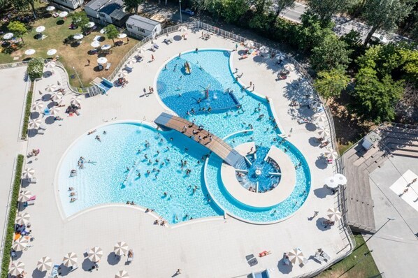 An aerial view of a large, multi-level swimming pool complex with various pool shapes and a central slide. - Vacation village Adriano Chalet Superior for 5 persons (Punta Marina Terme)