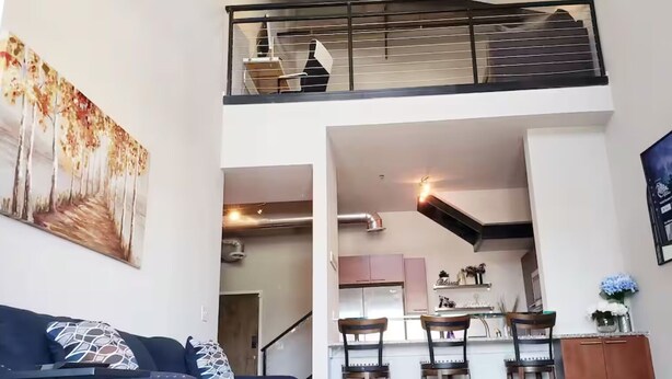 A modern apartment with a living room, dining area, kitchen, and a balcony.