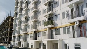 Un edificio residencial de varios pisos con balcones, piscina y un indicador de profundidad visible.