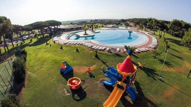 A children's play area with a large circular pool, slides, and a water fountain. - Vacation Village California Superior Vulci Cottage for 4 persons (Montalto Marina)