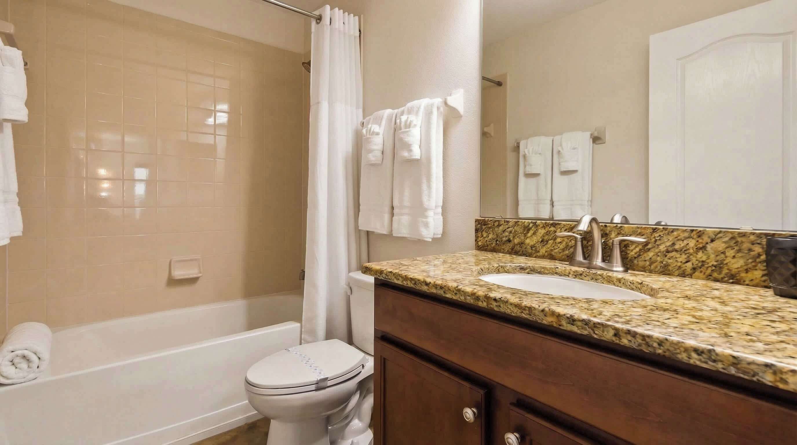 Un baño con bañera, inodoro, lavabo y tocador.