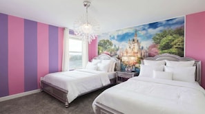 A bedroom with two beds, a chandelier, and a castle mural on the wall.