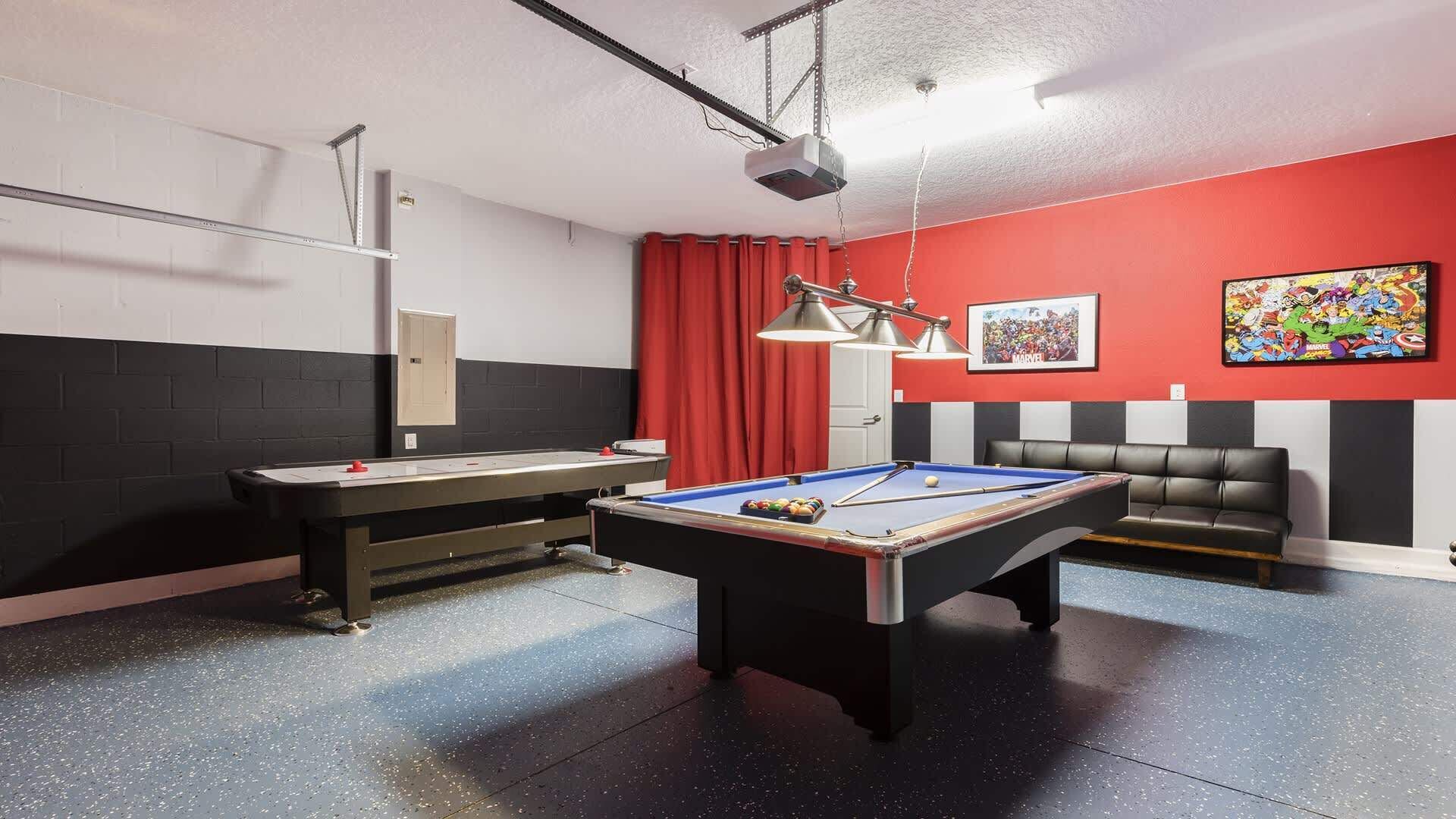 A pool table with a billiards cue, a red curtain, a black and white striped wall, and a black leather couch.