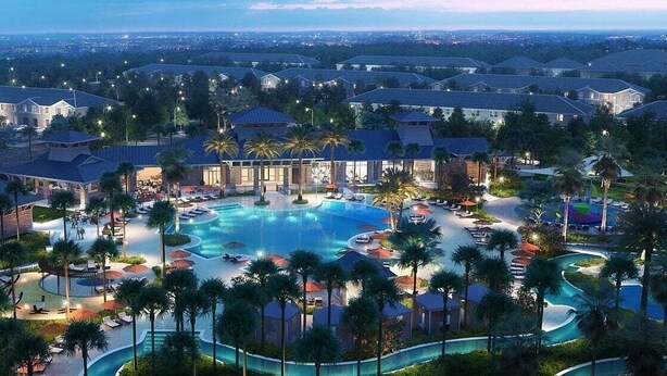 Ein Resort mit mehreren Schwimmbecken, Palmen und Blick auf die Stadt im Hintergrund.