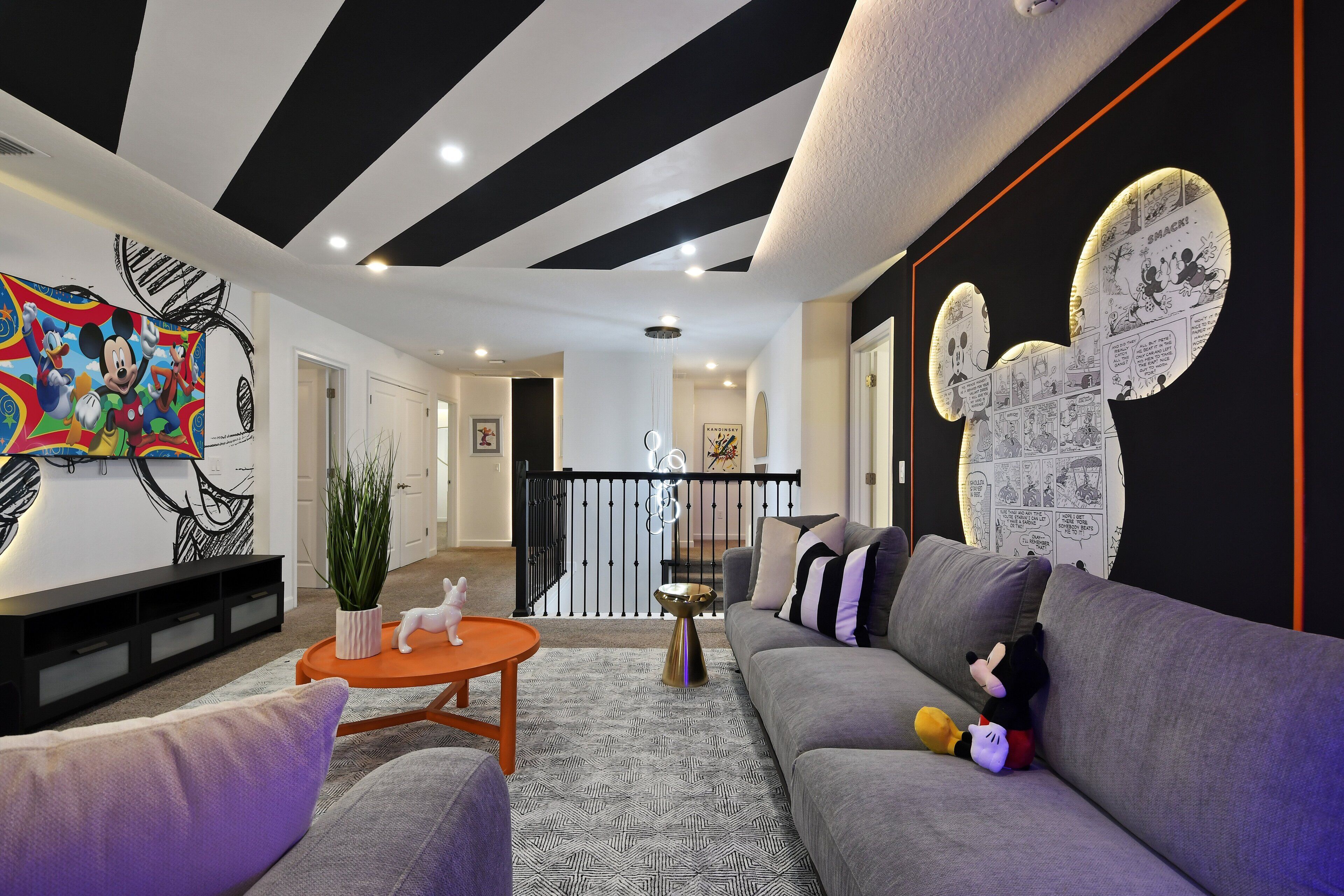 A modern living room with a grey sofa, a coffee table, and a colorful abstract painting on the wall.
