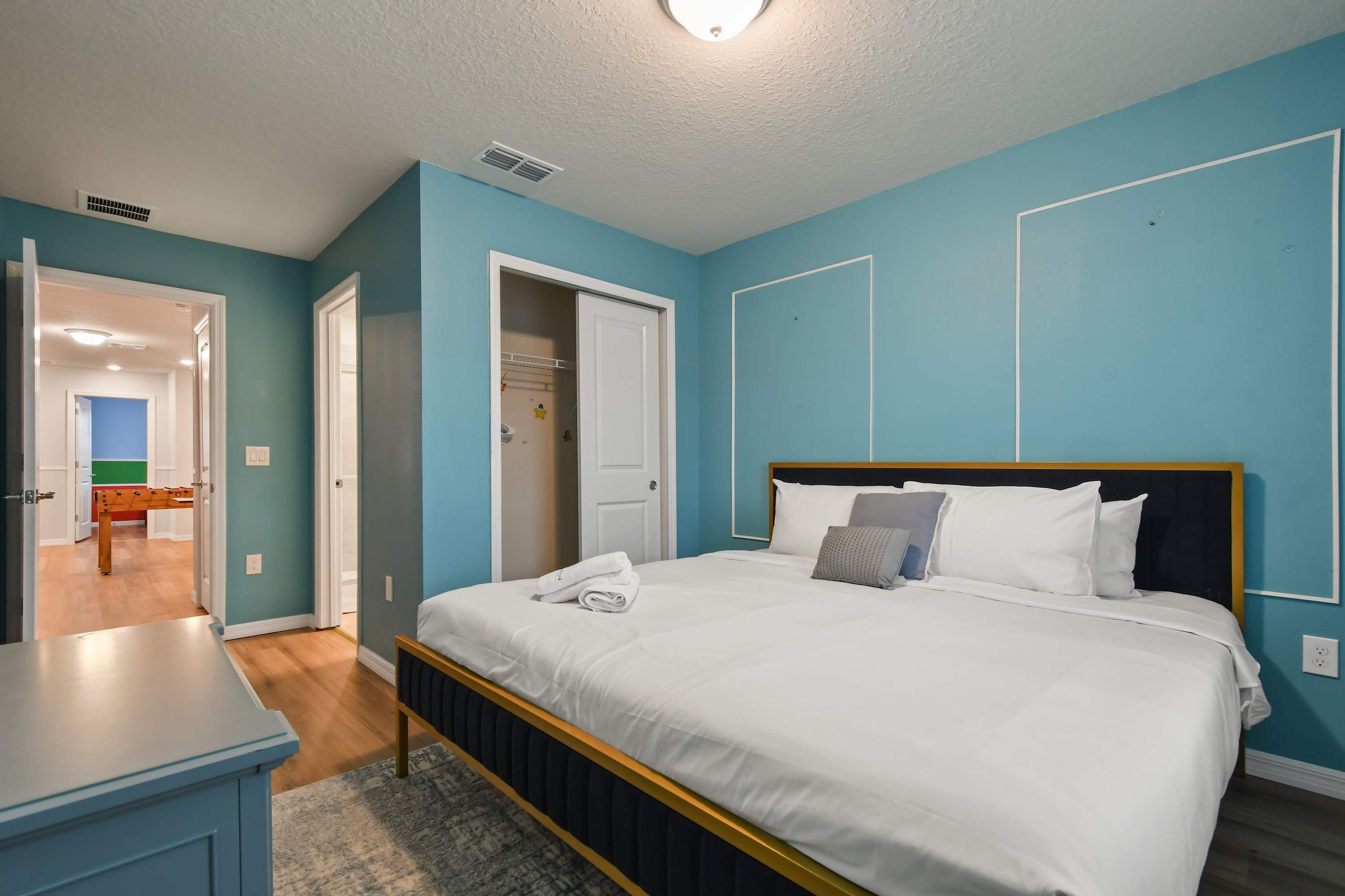 Une chambre à coucher comprenant un lit, une table de chevet et une porte donnant accès à une salle de bain.