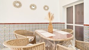 A dining area with a round table, wicker chairs, and decorative wall mirrors. - 'Animas 1' Apartment with Balcony, Wi-Fi, and Air Conditioning (Nerja)