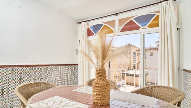 A balcony with wicker furniture, a table with a geometric table runner, and a vase with dried plants. - 'Animas 1' Apartment with Balcony, Wi-Fi, and Air Conditioning (Nerja)