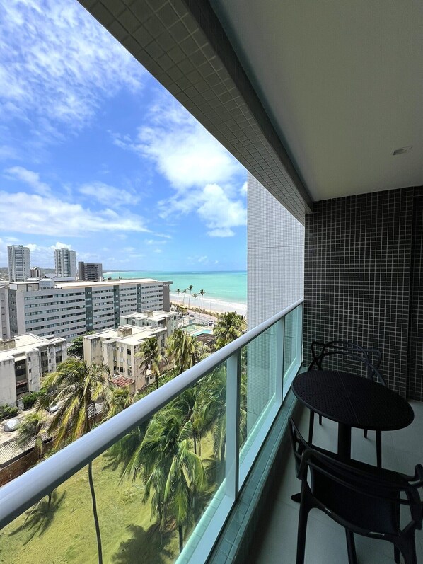 A balcony with a view of a beach and cityscape.