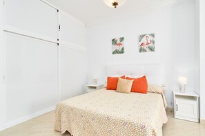 A bedroom with a bed, two pillows, a nightstand, a lamp, and two wall art pieces. - Duplex Home Next to Balcón de Europa with 2 Large Sunny Terraces and Barbecue (Nerja)
