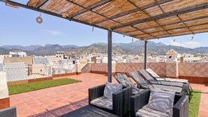 A rooftop terrace with outdoor furniture, a pergola, and a view of distant mountains. - Duplex Home by Balcón de Europa with 2 Large Sunny Terraces and Barbecue (Nerja)