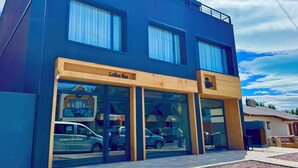 A modern building with a coffee bar and a sign for 'ABRA'. - MABRA SUITES (El Calafate)