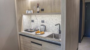A modern kitchen with a built-in countertop, a sink, and a wine glass holder. - MABRA SUITES (El Calafate)