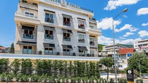 Un hôtel à plusieurs étages doté de balcons, un ciel dégagé et un lampadaire.