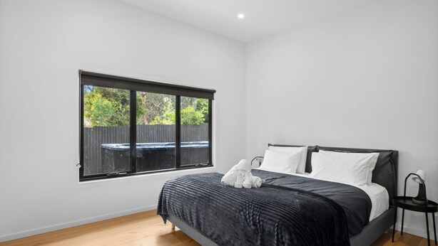 Quarto com cama, janela e vista para o quintal.