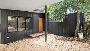 Uma casa moderna com uma janela ampla, porta de madeira e entrada com pedrisco.